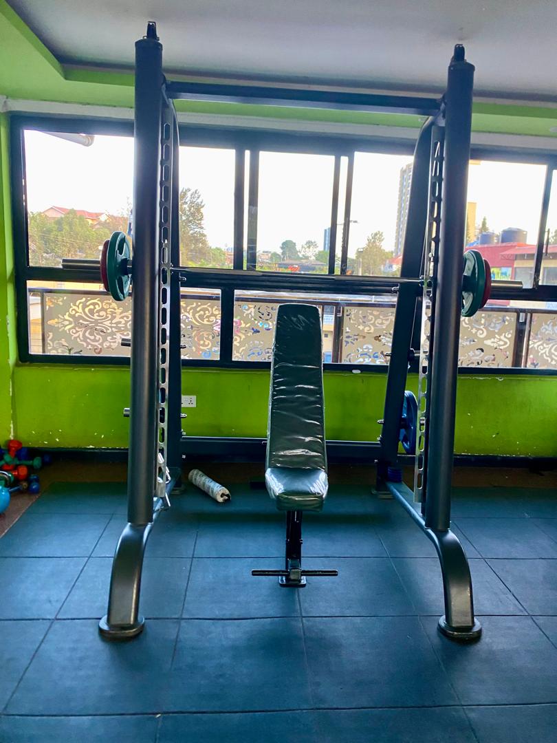 Smith machine loaded with plates and an upright bench at Shiloh Gym